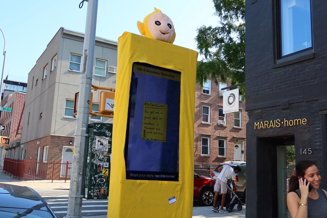 This is a photo of a LinkNYC kiosk in a Teletubby suit.